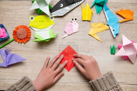 Photo for Girl's hand playing with origami - Royalty Free Image