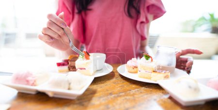 Foto de Una mujer que come un montón de dulces - Imagen libre de derechos