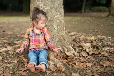 Téléchargez les photos : Fille appuyée contre un arbre - en image libre de droit