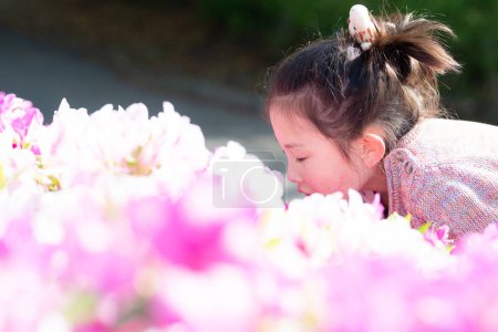 Photo for Girl smelling the scent of flowers - Royalty Free Image