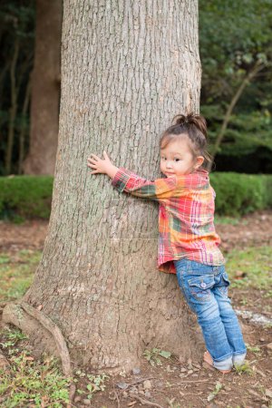 Foto de Niña abrazando un árbol - Imagen libre de derechos