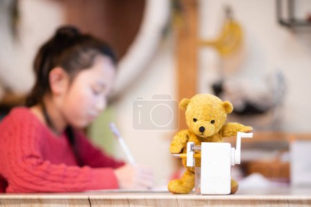 Photo for Teddy bear sharpens a pencil - Royalty Free Image