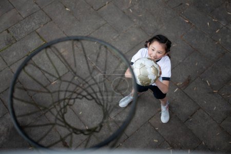 Photo for Child in gym clothes playing basketball - Royalty Free Image