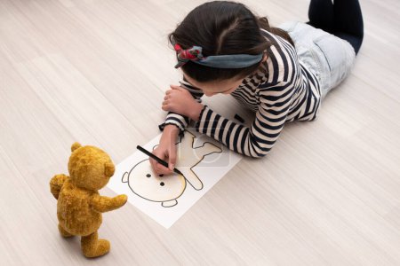 Téléchargez les photos : Une fille dessine une image d'ours en peluche - en image libre de droit