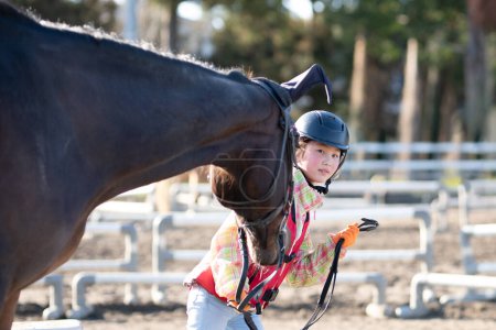 Téléchargez les photos : Fille apprendre à monter un cheval - en image libre de droit