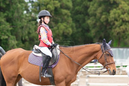 Foto de Chica usando un casco disfrutando de montar a caballo - Imagen libre de derechos