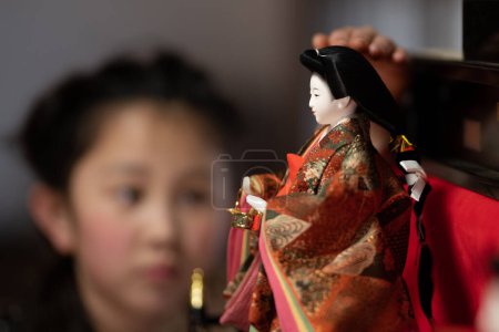 Chica mirando a la muñeca japonesa Hina