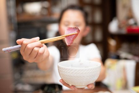 Photo for A child eating bonito sashimi - Royalty Free Image