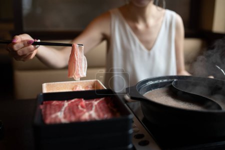 Foto de Mujer comiendo comida japonesa shabu-shabu - Imagen libre de derechos