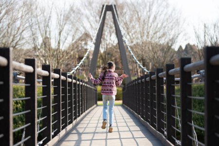 Foto de Chica caminando en puente colgante - Imagen libre de derechos