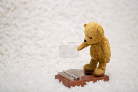 Photo for Teddy bear playing the kalimba - Royalty Free Image