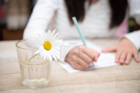 Photo for A child studying with flower in a cup - Royalty Free Image