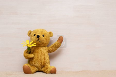 Photo for Teddy bear with yellow flower - Royalty Free Image