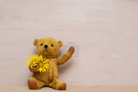 Photo for Teddy bear with yellow flowers - Royalty Free Image