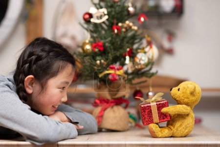 Foto de Chica recibiendo un regalo de Navidad de un oso de peluche - Imagen libre de derechos
