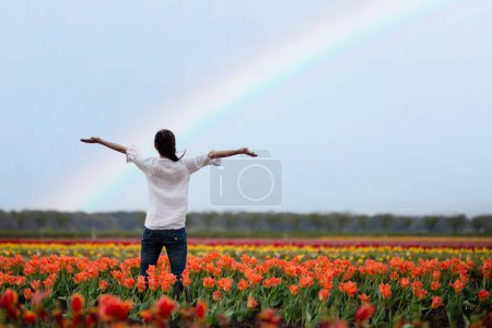 Foto de Brazos abiertos de mujer en campo de flores de arco iris - Imagen libre de derechos