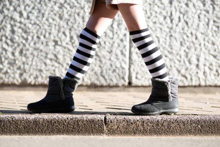 Téléchargez les photos : Un enfant portant des bottes marche - en image libre de droit