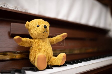 Téléchargez les photos : Ours en peluche assis sur le clavier du piano - en image libre de droit