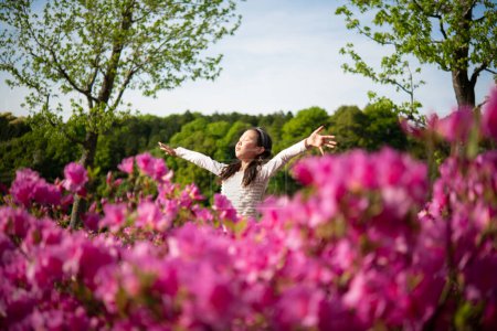 Foto de Chica brazos abiertos en jardín de flores - Imagen libre de derechos