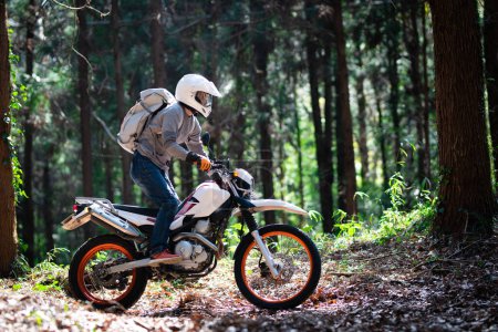 Foto de Un hombre montando una motocicleta todoterreno en un camino de montaña - Imagen libre de derechos