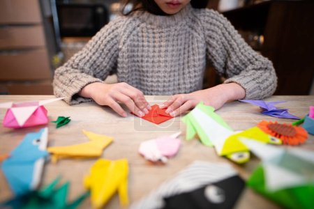 Téléchargez les photos : Main de fille jouant avec origami - en image libre de droit