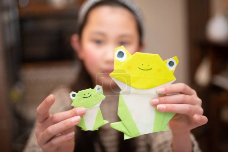 Foto de Una chica con ranas de origami - Imagen libre de derechos