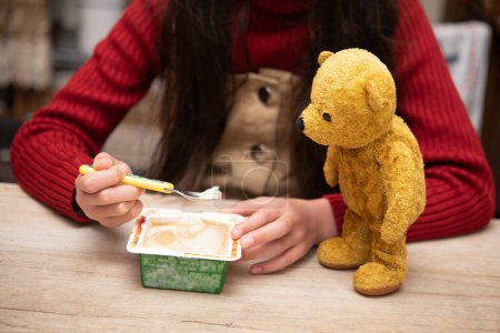 Photo for Teddy bear looking at child's ice cream - Royalty Free Image