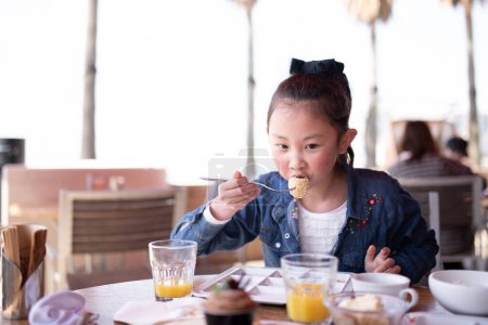 Photo for Girl eating at a restaurant - Royalty Free Image