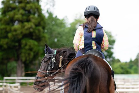 Téléchargez les photos : Mignonne fille appréciant l'équitation - en image libre de droit