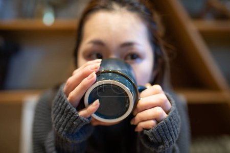 Téléchargez les photos : Femme buvant du café dans une tasse - en image libre de droit