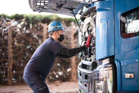 Téléchargez les photos : Un homme inspectant un camion lourd - en image libre de droit