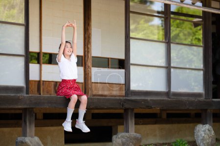 Foto de Una chica relajándose en el porche de una casa japonesa - Imagen libre de derechos