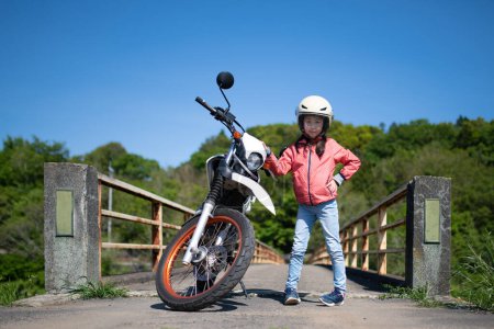 Téléchargez les photos : Fille posant à côté d'une moto - en image libre de droit