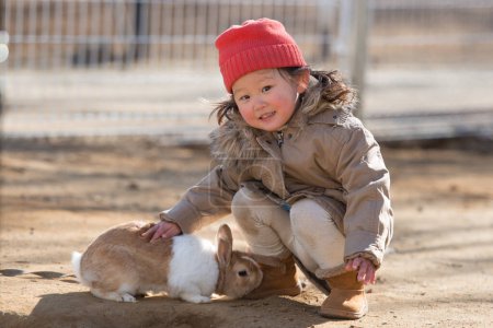 Photo for Cute little girl with a bunny rabbit - Royalty Free Image