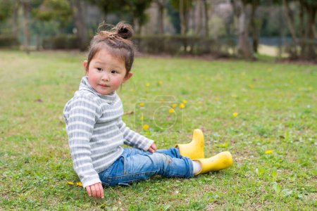 Téléchargez les photos : Fille assise sur l'herbe dans le parc - en image libre de droit