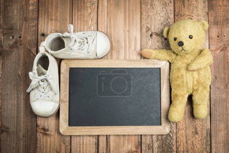 Photo for Blackboard and teddy bear and children's shoes - Royalty Free Image