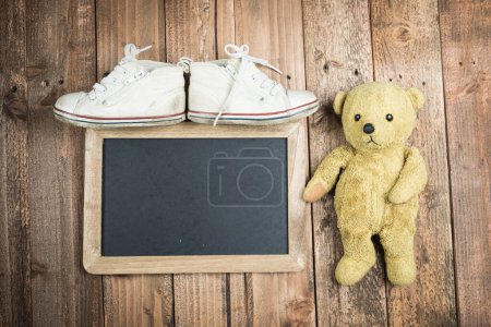 Photo for Blackboard and teddy bear and children's shoes - Royalty Free Image