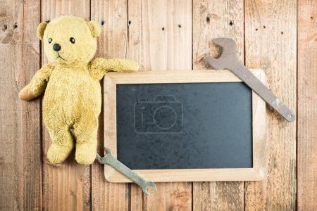 Old tools and teddy bear and blackboard