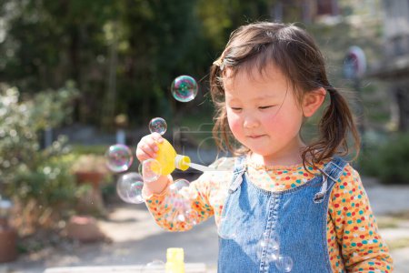 Téléchargez les photos : Fille jouer avec des bulles de savon - en image libre de droit