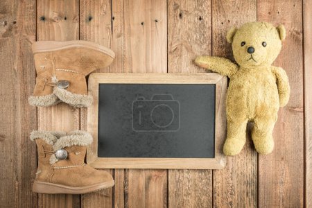Téléchargez les photos : Bottes et tableau noir et ours en peluche sur fond en bois - en image libre de droit