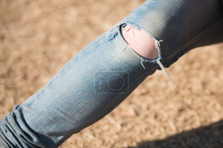 Téléchargez les photos : Pied de femme portant un jean avec trou - en image libre de droit