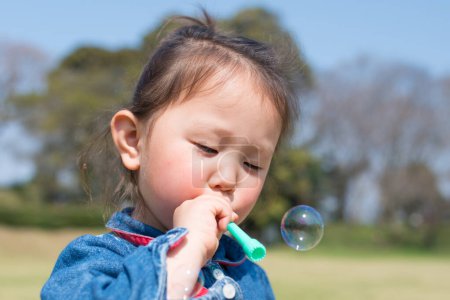 Photo for Girl playing with soap bubbles - Royalty Free Image