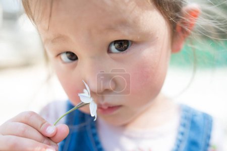 Foto de Chica hueles el aroma de la flor blanca - Imagen libre de derechos