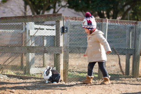 Téléchargez les photos : La fille a trouvé du lapin à la ferme - en image libre de droit