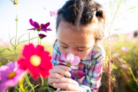Foto de Chica huele la fragancia de las flores en el jardín de flores - Imagen libre de derechos