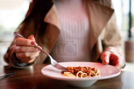 Téléchargez les photos : Femme mangeant des spaghettis dans un café - en image libre de droit