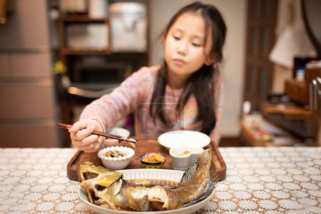 Photo for Girl to eat with chopsticks - Royalty Free Image