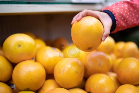 Téléchargez les photos : Femme choisir des oranges de supermarché - en image libre de droit