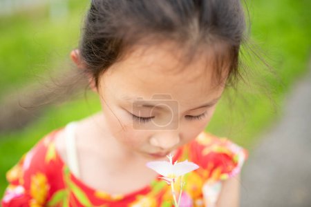 Téléchargez les photos : Fille renifler l'odeur d'une petite fleur - en image libre de droit