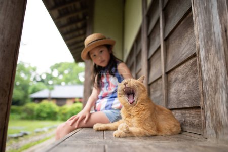 Téléchargez les photos : Chat et fille passer du temps sur le porche - en image libre de droit